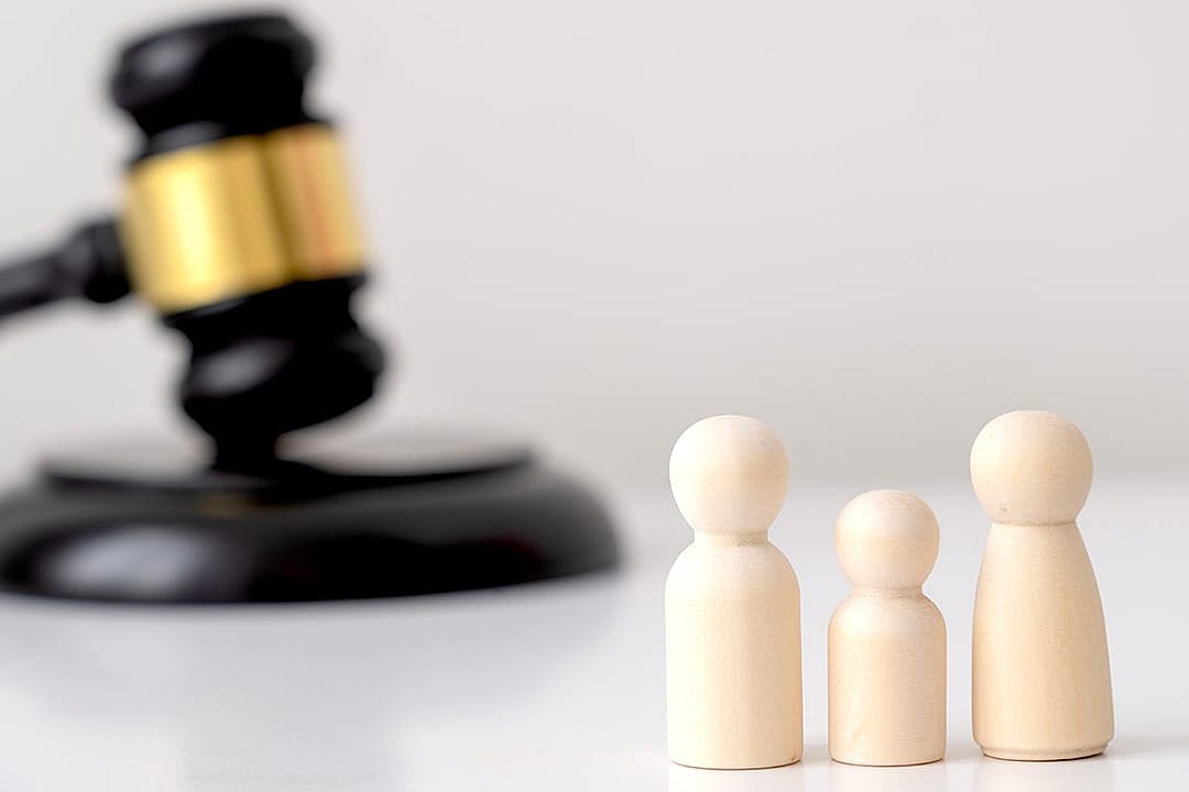 Small family figures and a wooden gravel at the back, representing legal family matters.